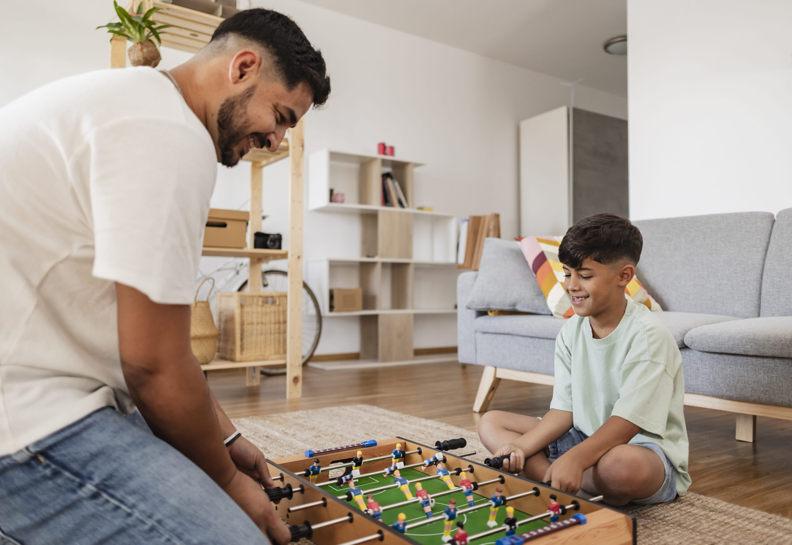 hispanic-father-with-his-son-at-home-playing-foosb-2023-11-27-05-30-53-utc